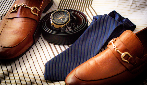 dress shoes with a belt, tie, and watch